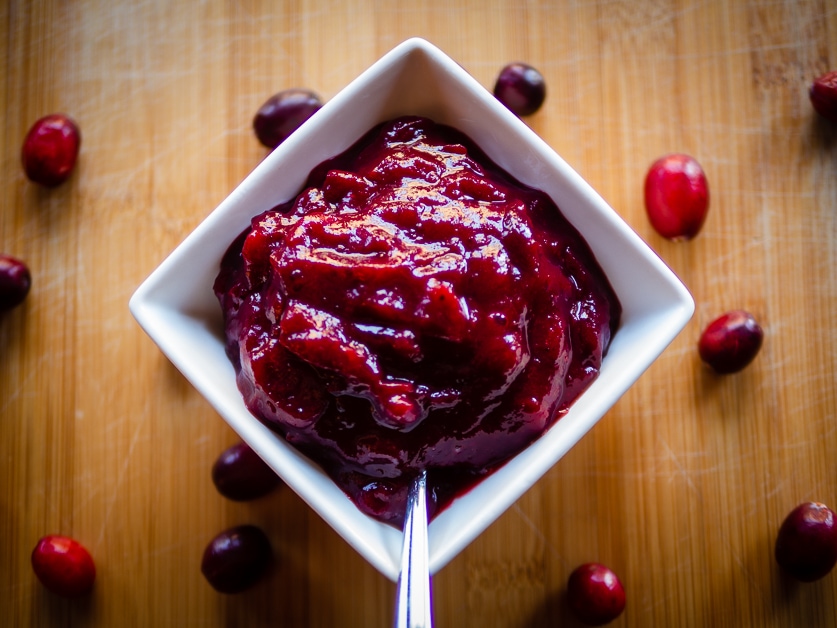 Cranberry sauce in a bowl with a spoon.