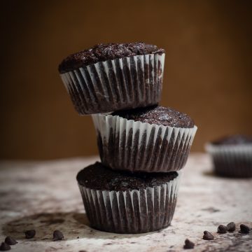 Three chocolate muffins stacked on one another.