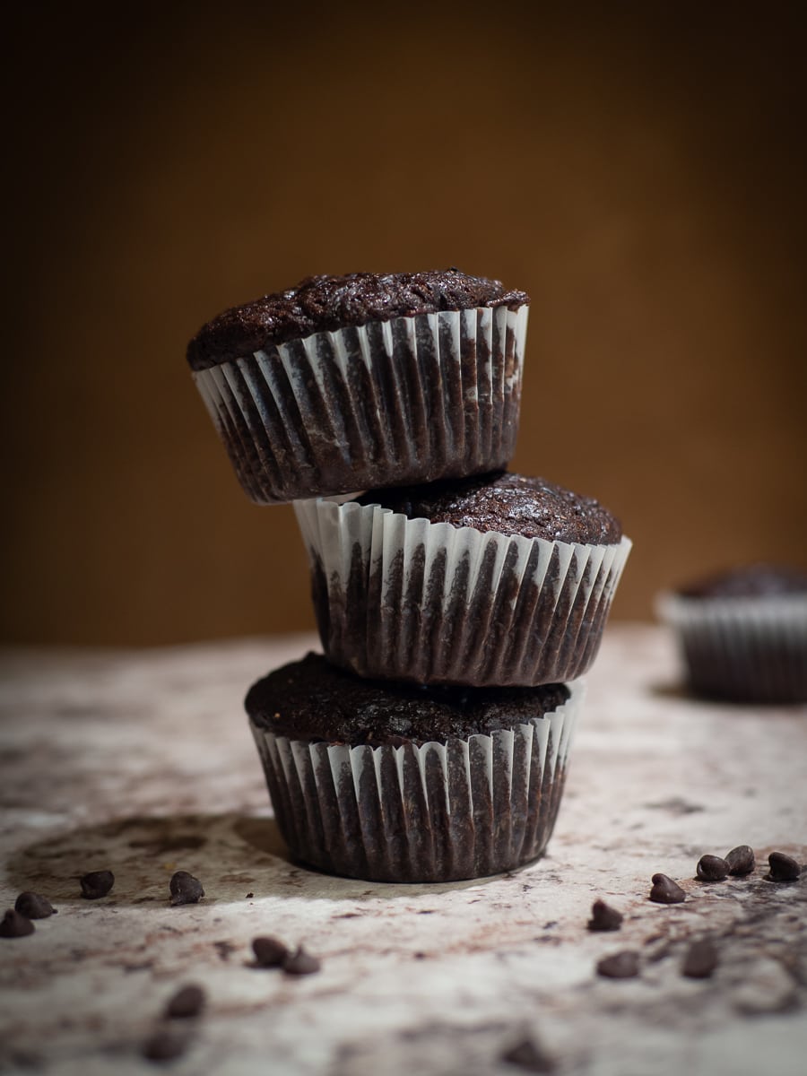 Three chocolate muffins stacked on one another.