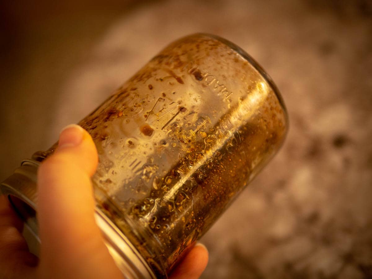 Hand shaking a jar with vinaigrette.