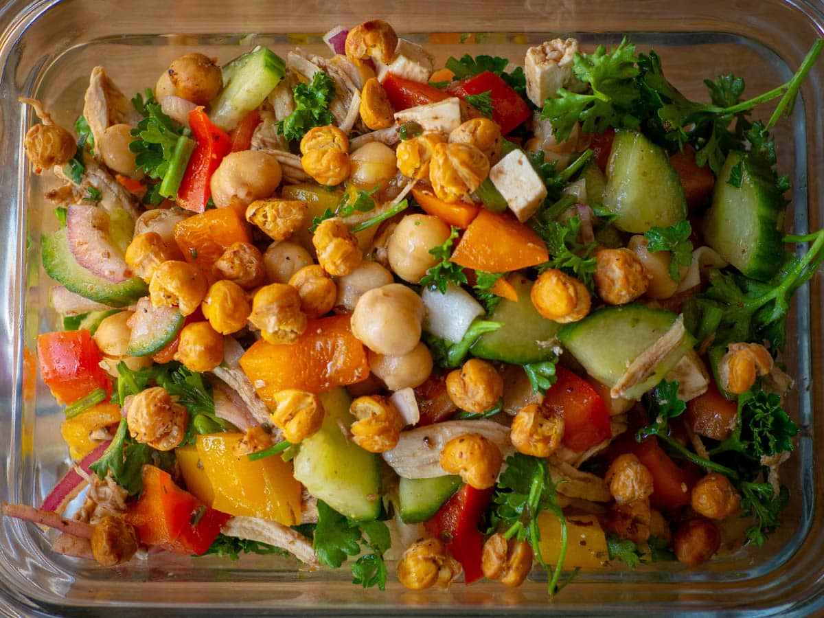 Glass container filled with Mediterranean chickpea salad.