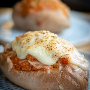 Stuffed sweet potato topped with melted cheese.