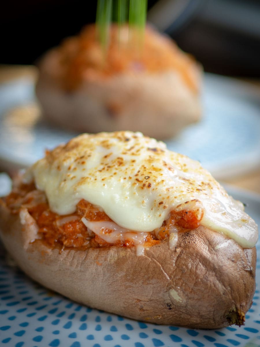 Stuffed sweet potato topped with melted cheese.