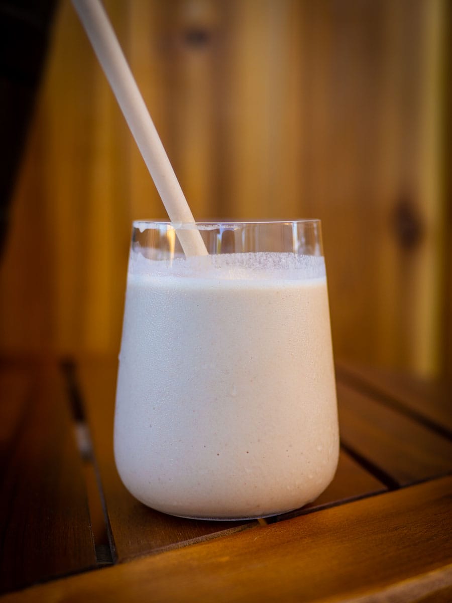 Chai Frappe with a straw sitting on a wooden table.