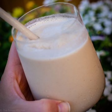 Hand holding a creamy colored frozen drink.