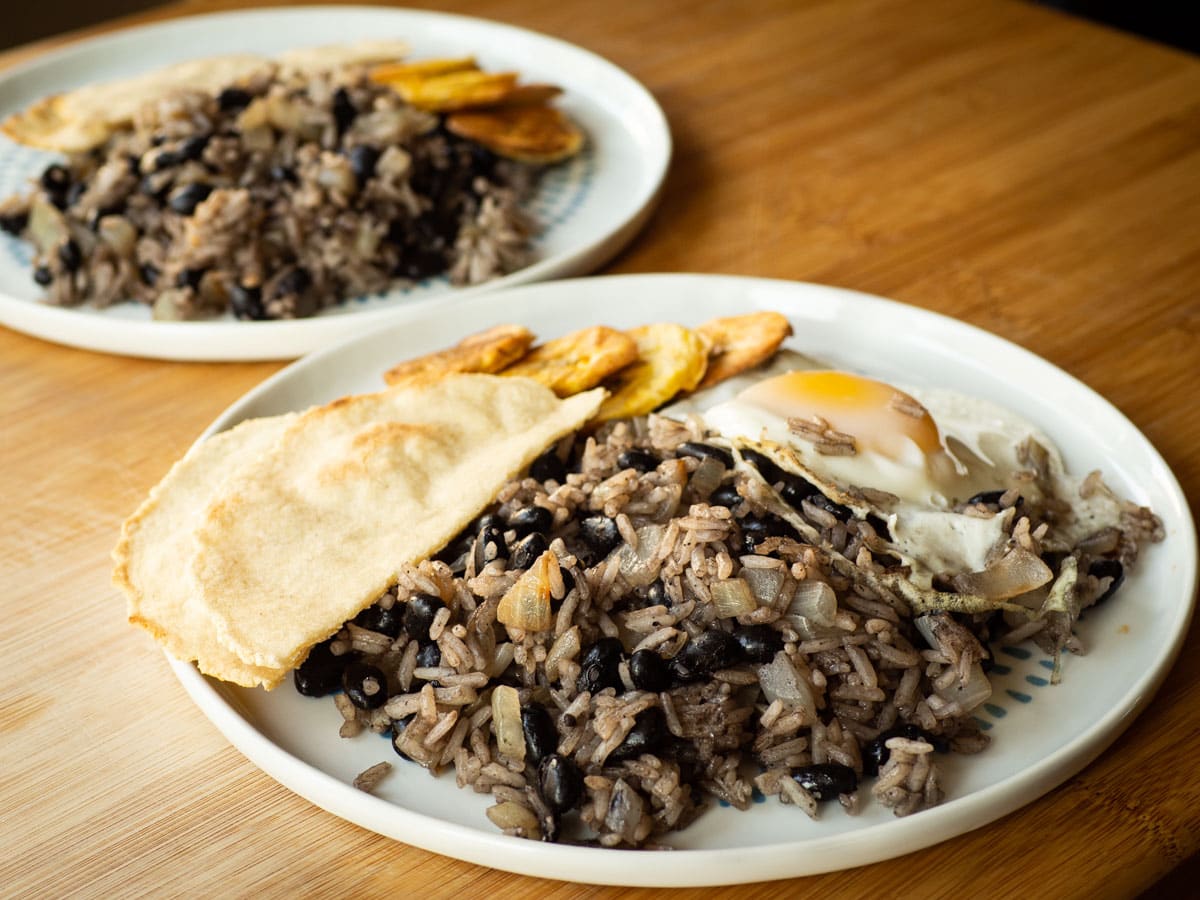 Gallo Pinto topped with egg and alongside a tortilla.