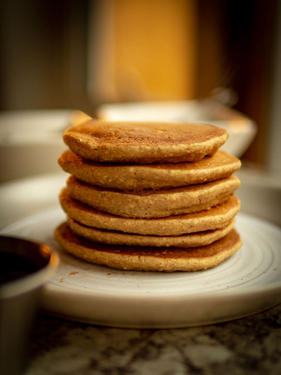 Stack of cooked pancakes on a plate.