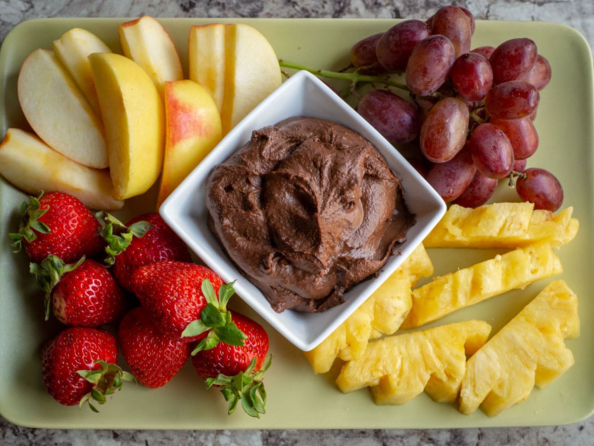 Chocolate hummus on a plate with fruit.