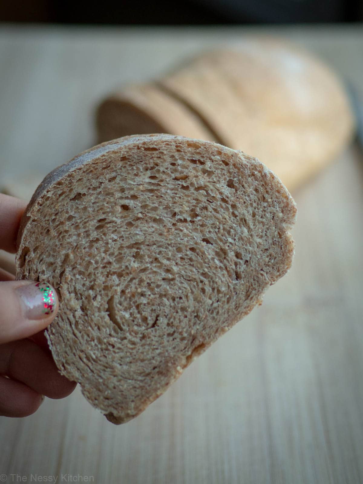 Hand holding a slice of bread.