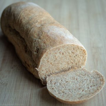 Loaf of sandwich bread with a slice cut off.