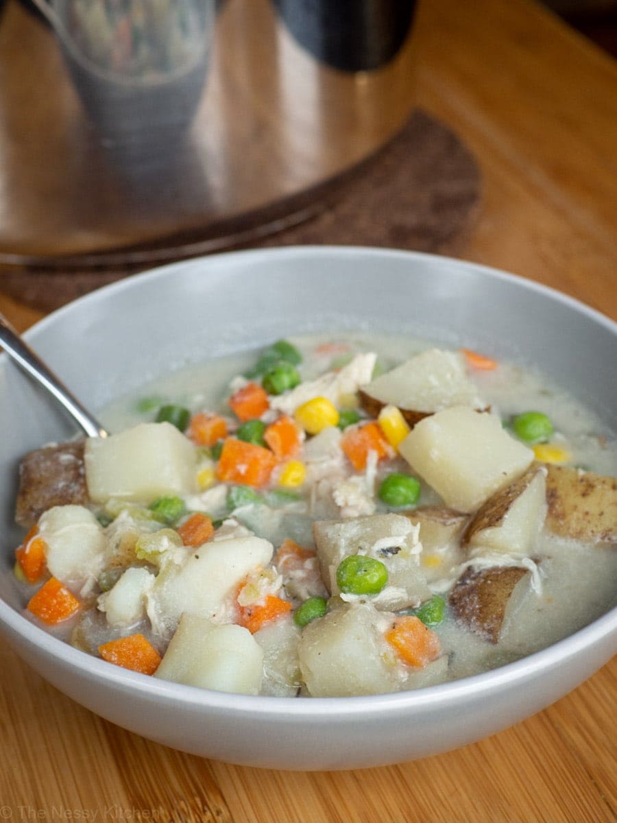 Bowl of pot pie soup next to a pot.