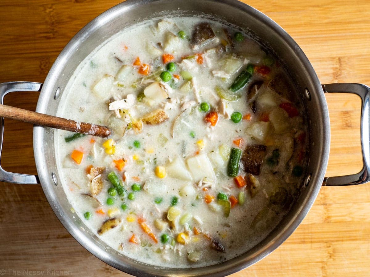 Large pot full of creamy chicken and vegetable soup.