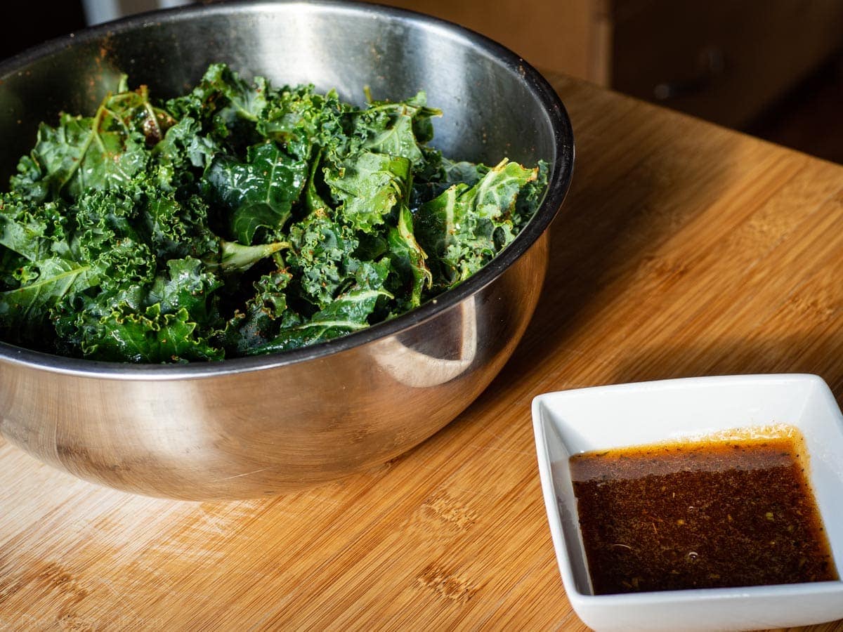 Ripped kale in a bowl and melted Cajun honey butter.