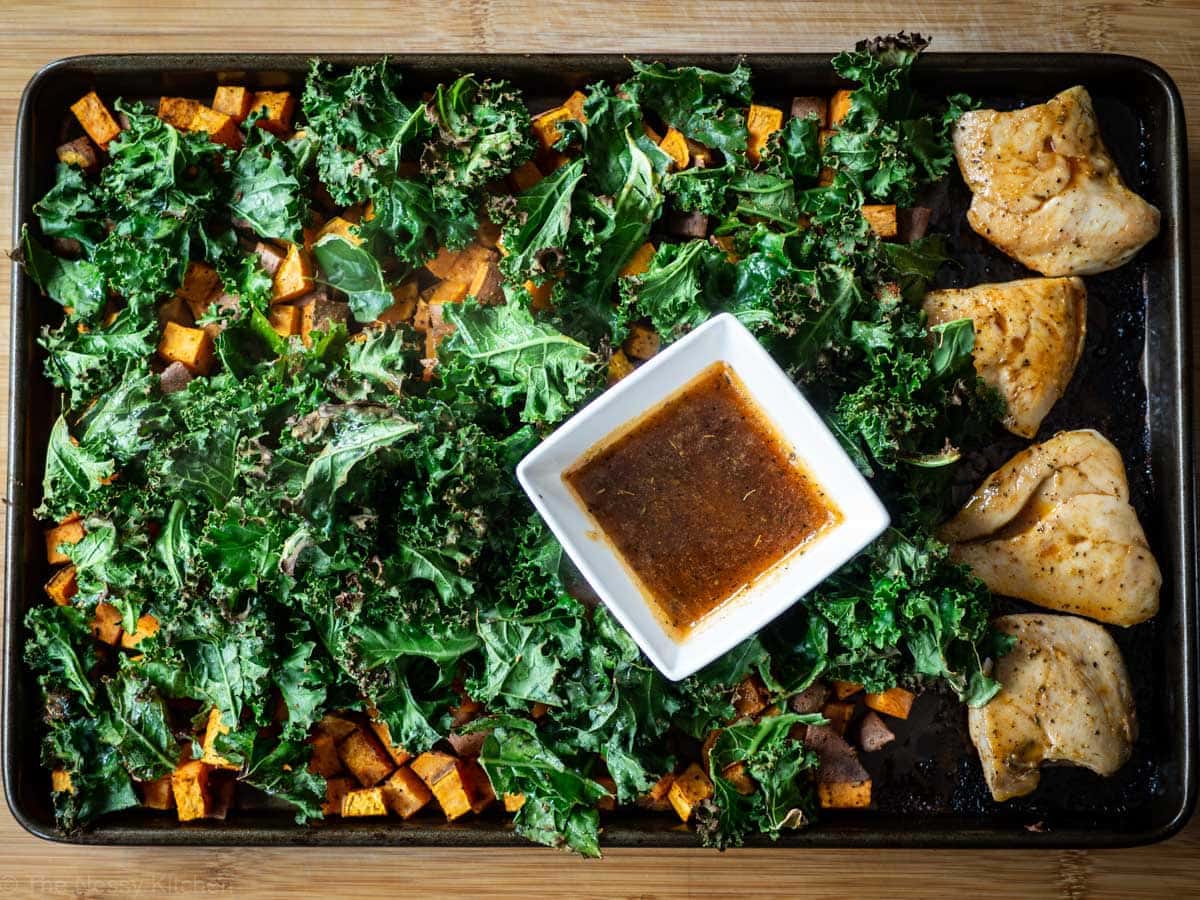 Cooked kale, sweet potatoes and chicken on a sheet pan.