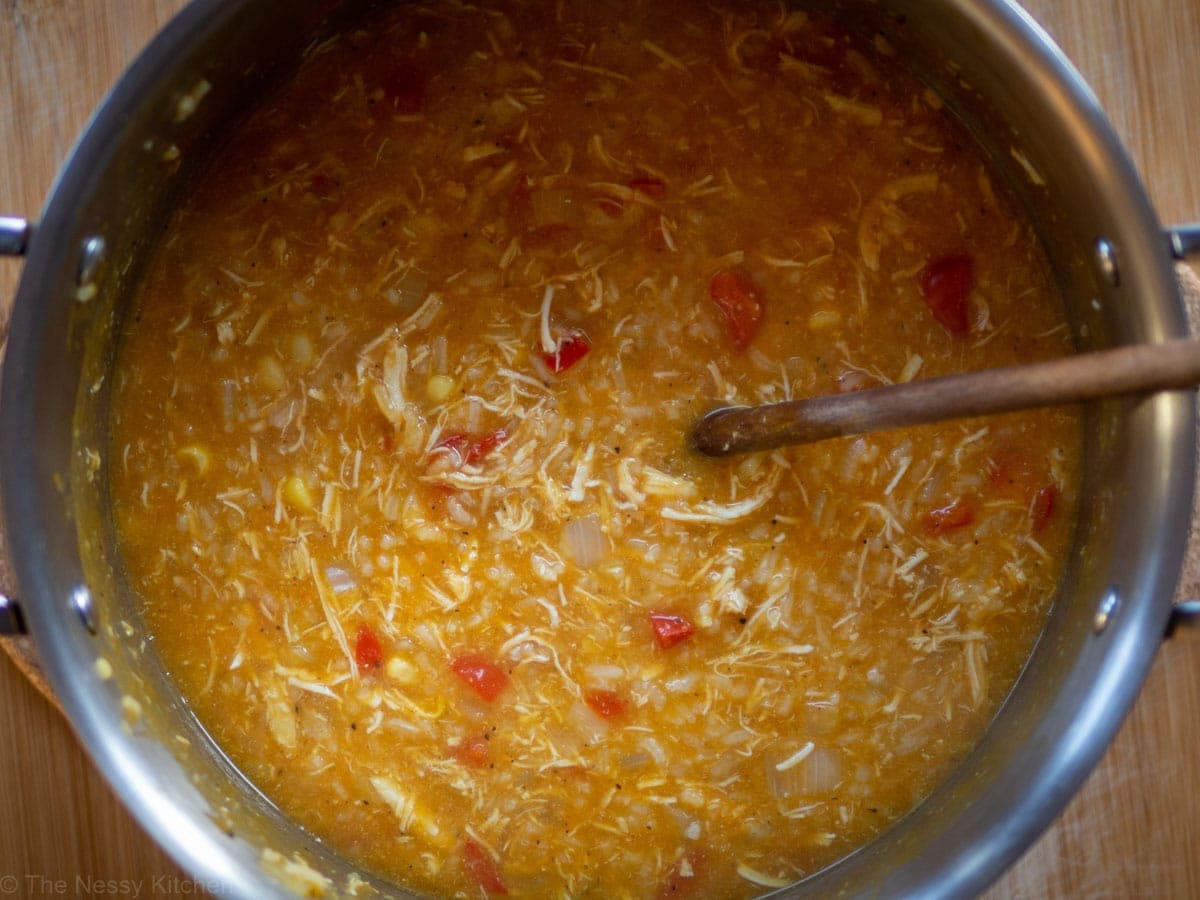 Top view of a pot of soup with a wooden spoon.