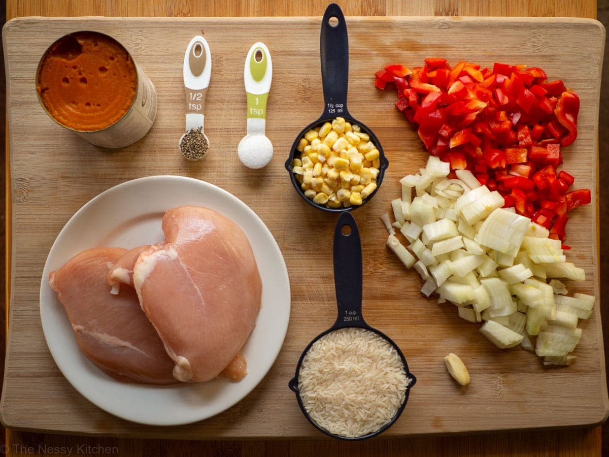 Ingredients for chicken pumpkin soup set out on a cutting board. 