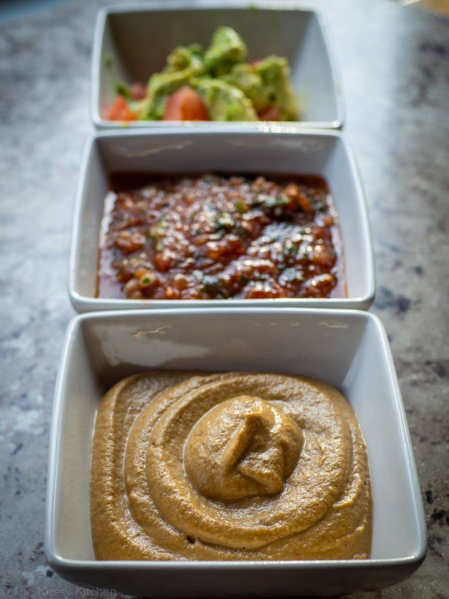 Bowl of queso alongside other dips.