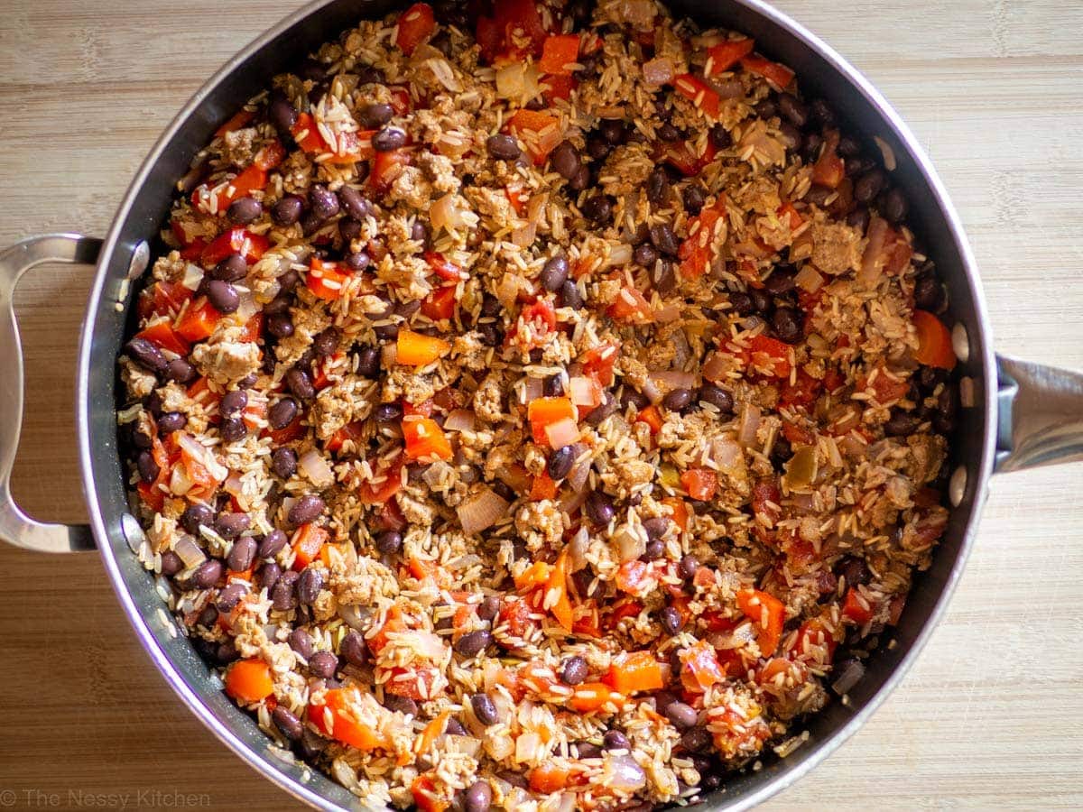 Rice, black beans, diced tomatoes, pepper, onions and chorizo in a skillet.