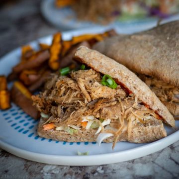 Pulled pork on a bun with sweet potato fries on the side.