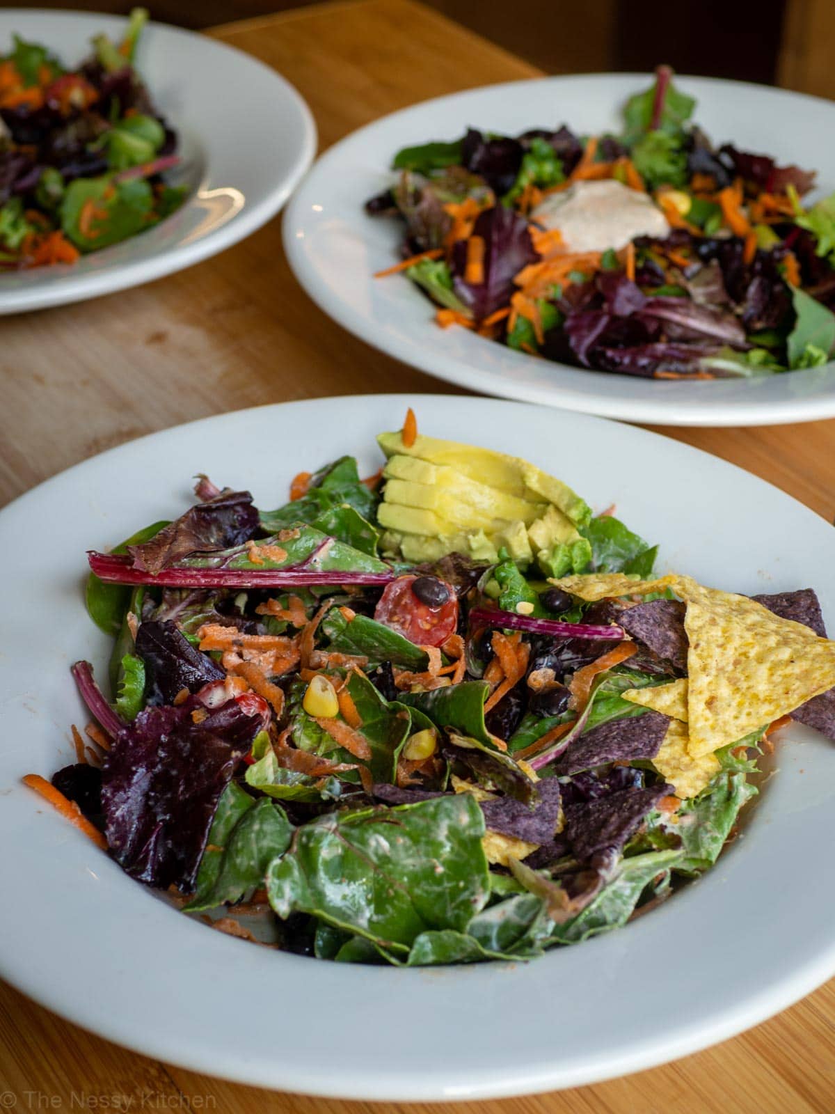 Bowl of salad with additional servings in the background.