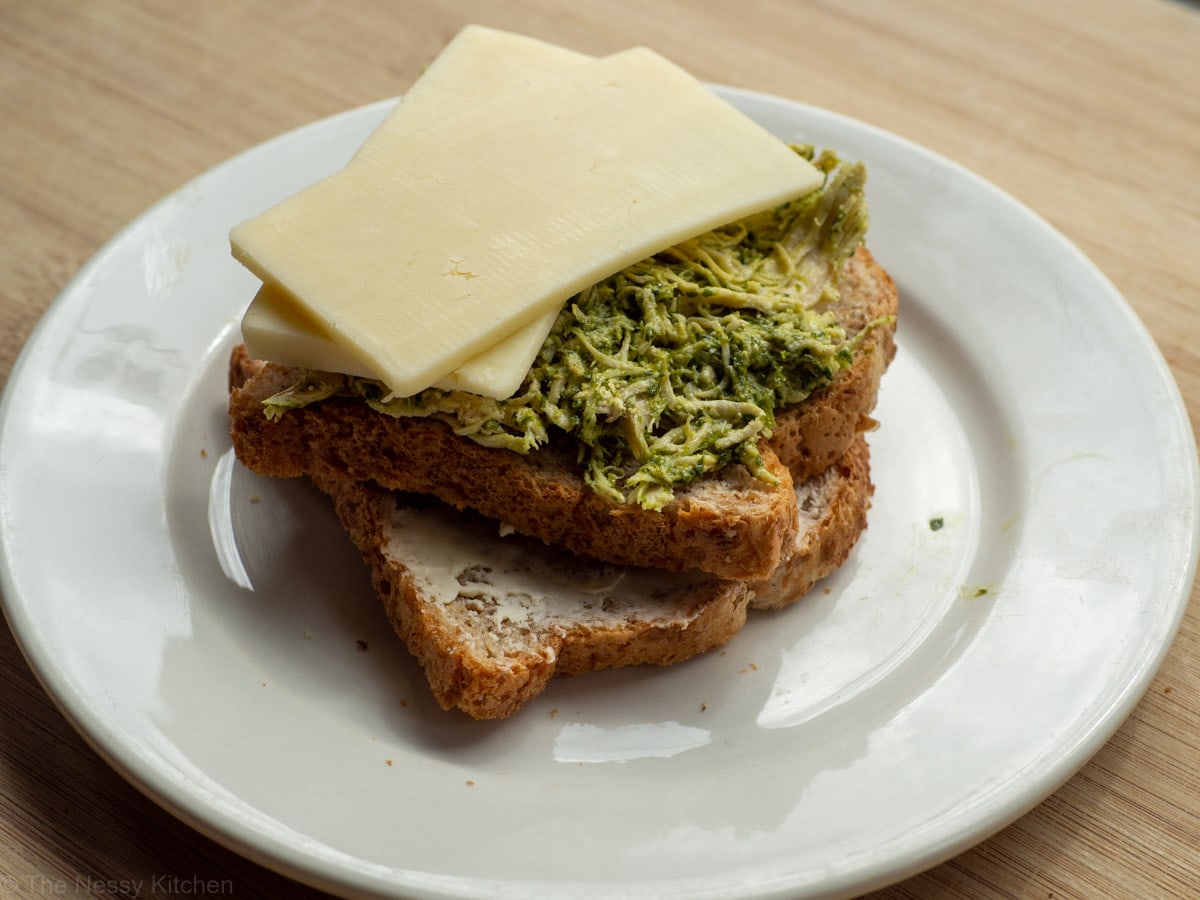 Assembly of a chimichurri chicken sandwich on a plate.