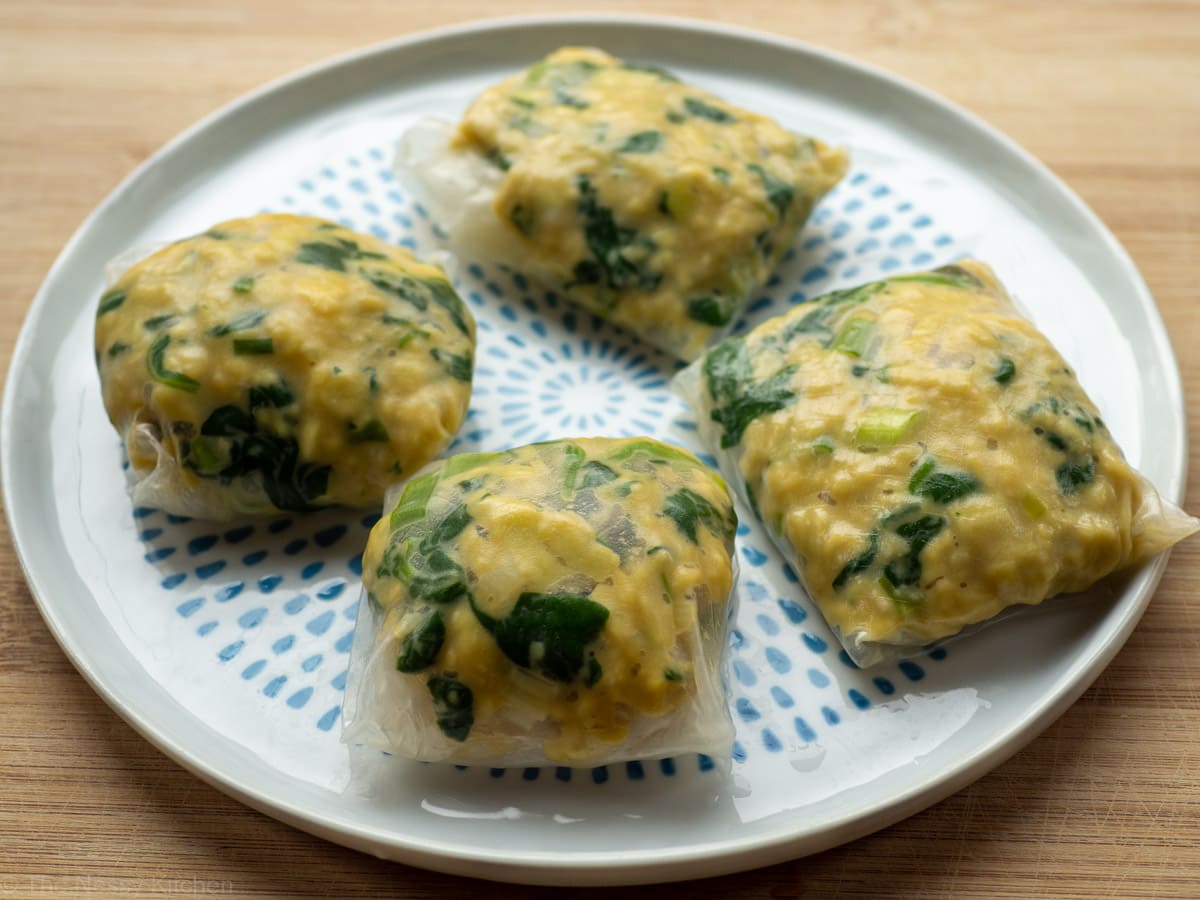 Scrambled eggs wrapped in rice paper prior to frying.