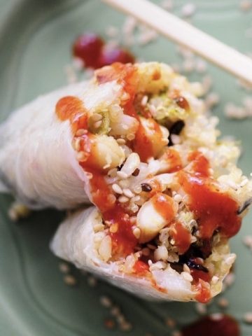 Rice paper roll slice in half and drizzled with hot sauce.