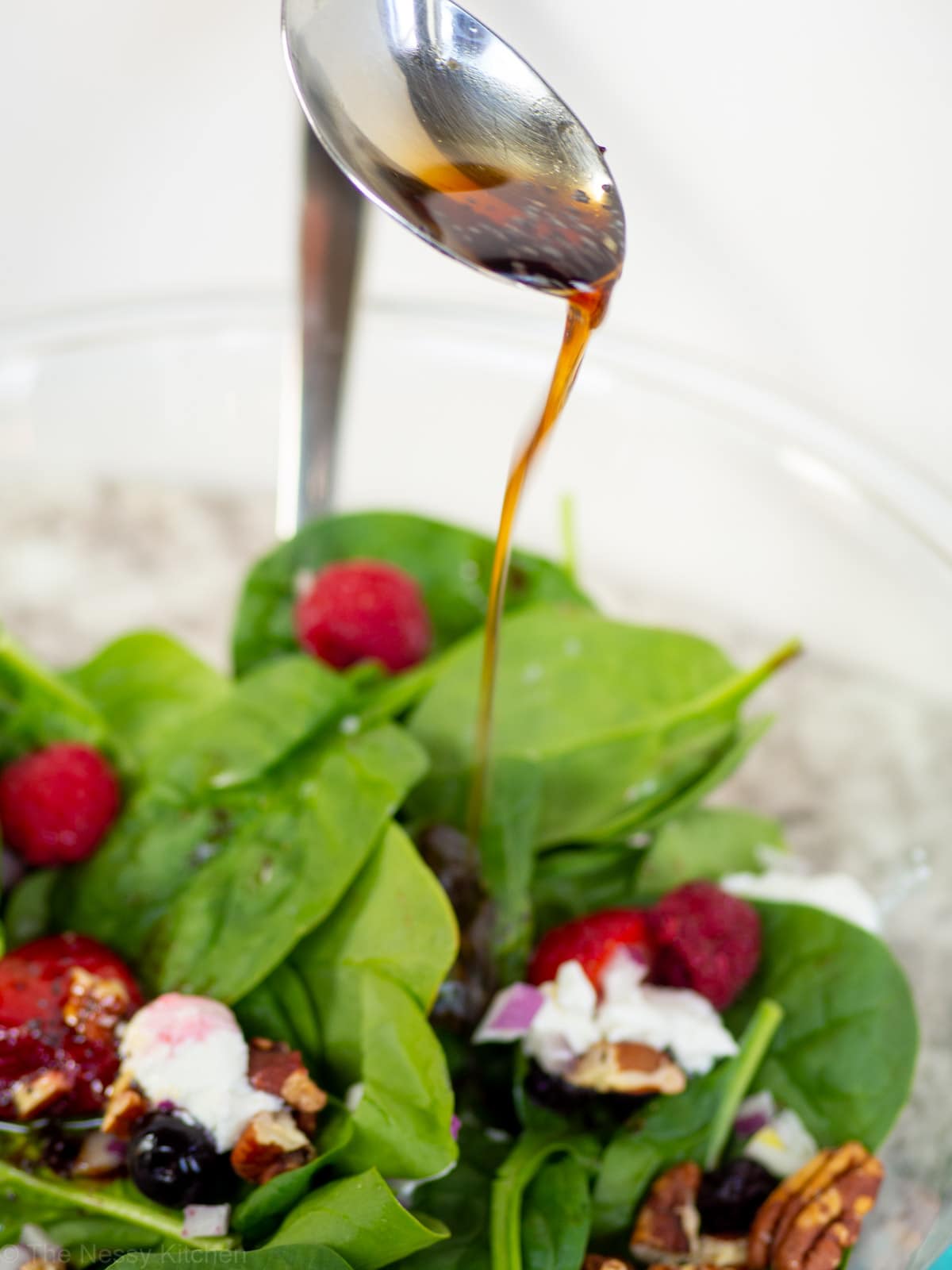 Maple balsamic dressing being drizzled on a salad.