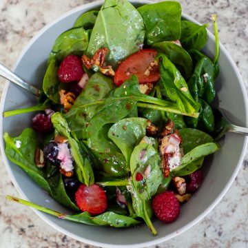Dished out bowl of berry spinach salad.