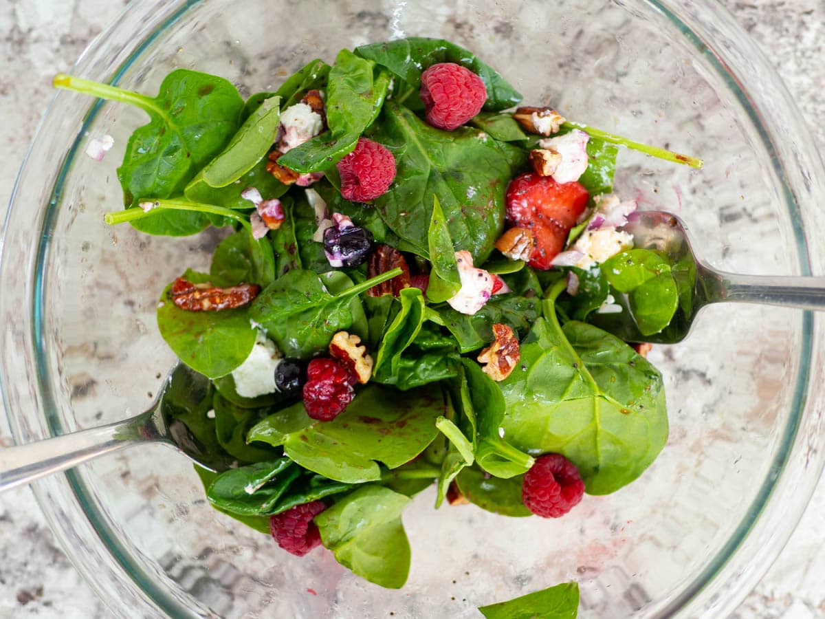 Bowl with salad and serving fork and spoon.