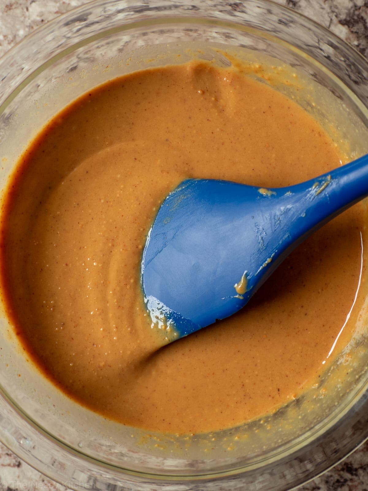 Bowl of peanut butter mixed with melted coconut oil.