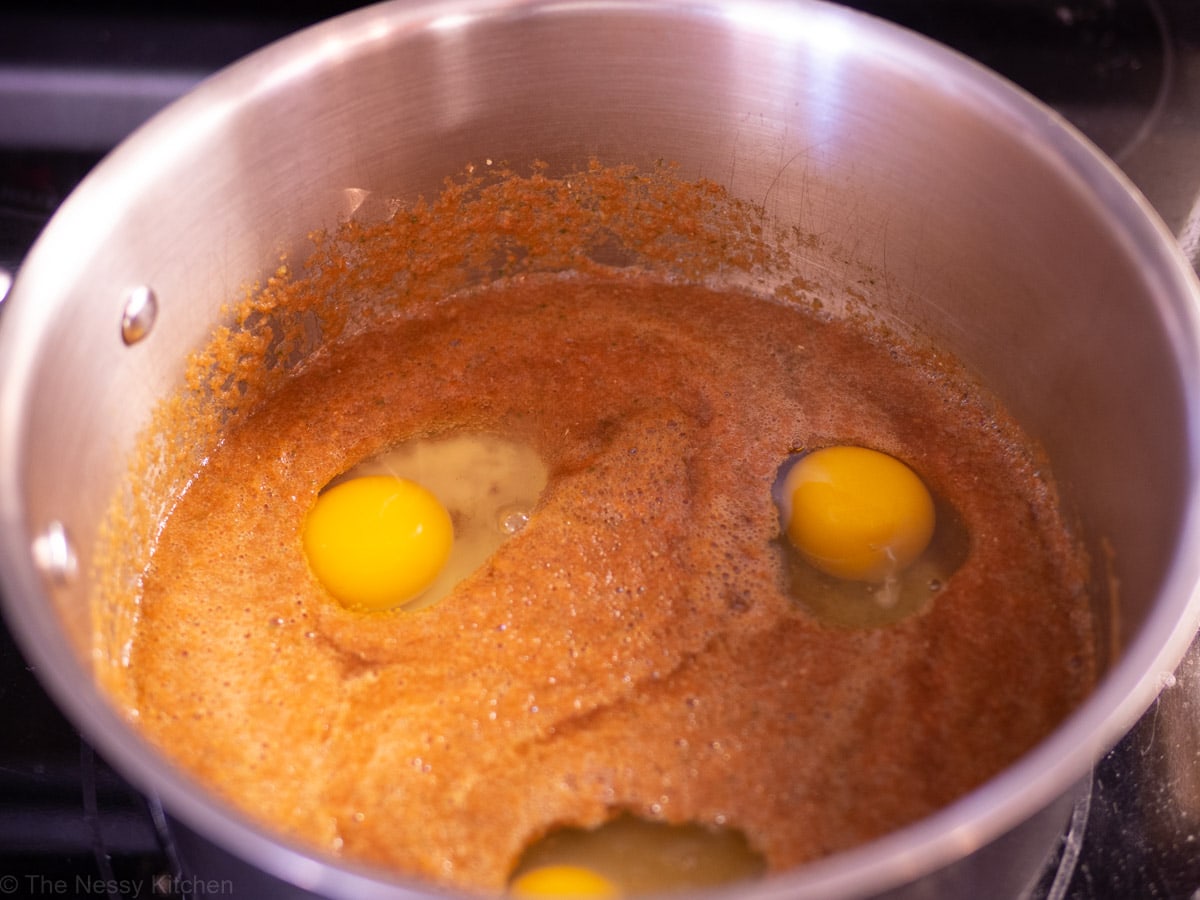 Eggs poaching in ranchero sauce.