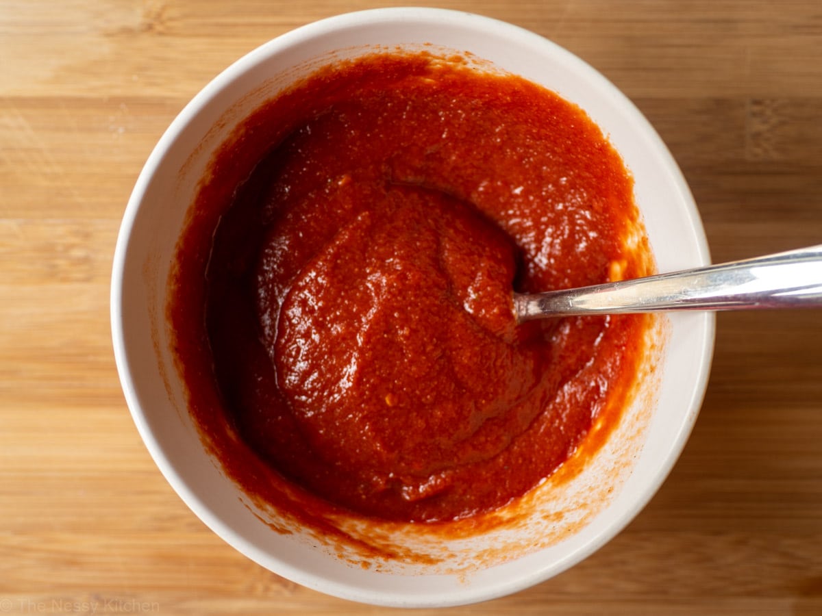 Pizza sauce ingredients stirred together.