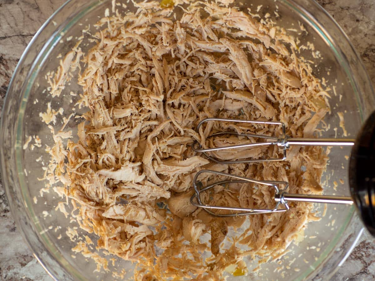 Chicken that has been shredded with a hand mixer.