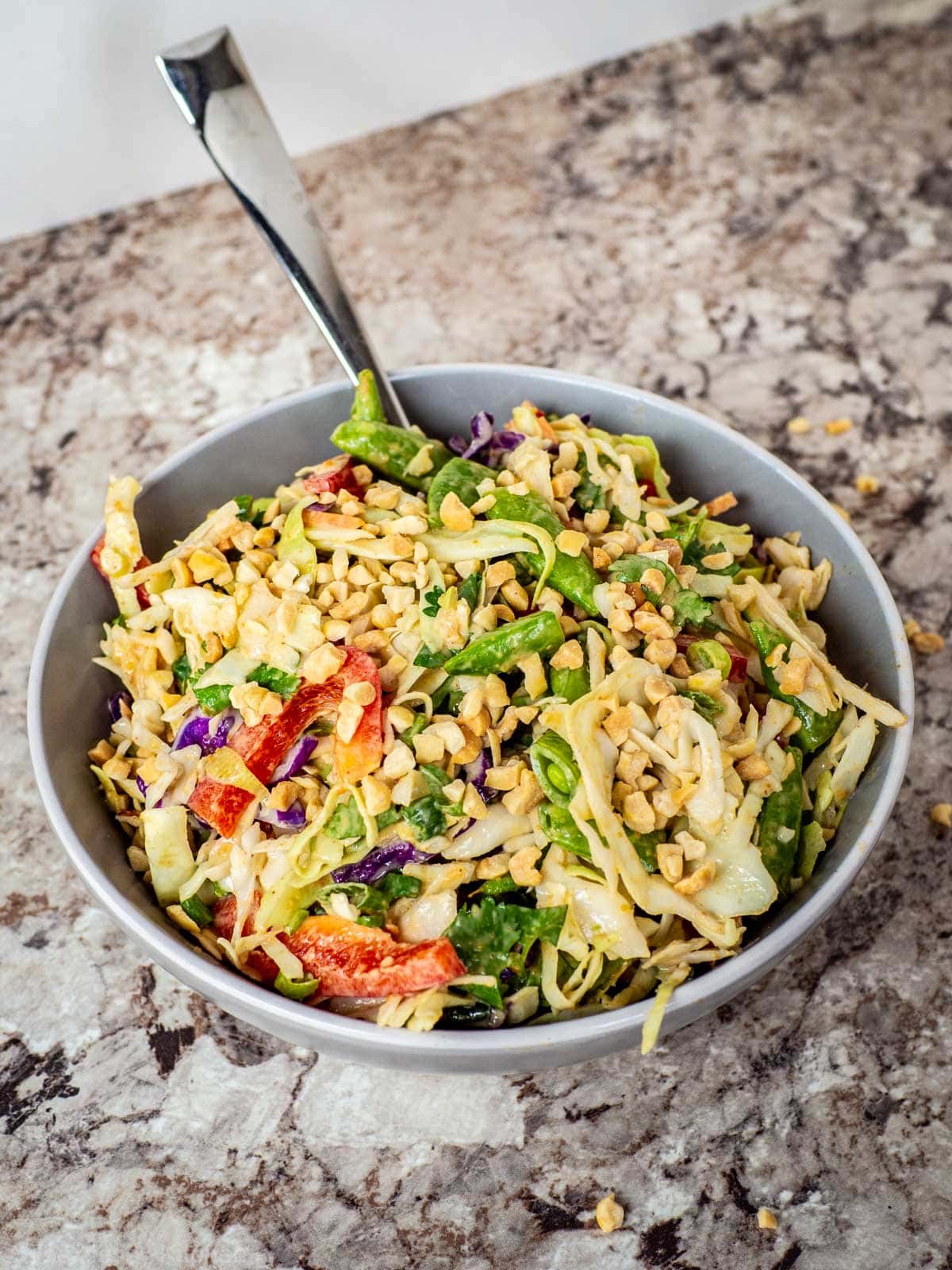 Bowl of Thai peanut salad topped with extra peanuts.