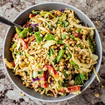 Bowl of Thai-inspired peanut slaw topped with chopped peanuts.