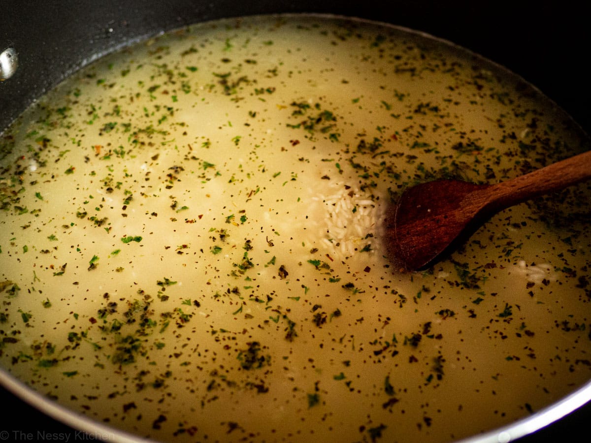 Seasonings and water added to skillet with rice.