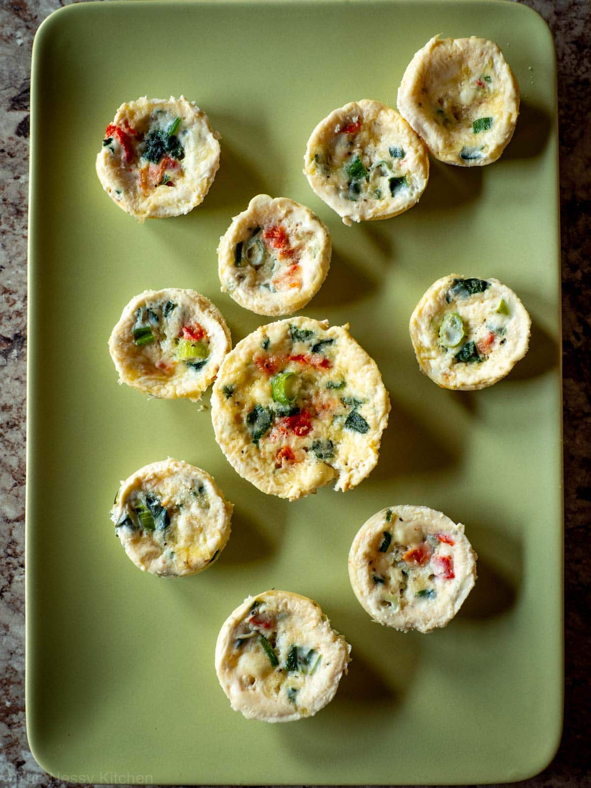 Egg white bites on a green plate.