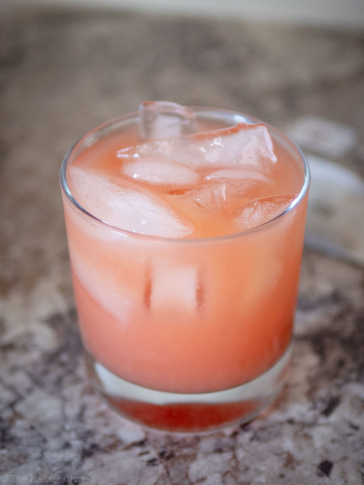 Iced Guava White Tea Lemonade in a glass with lots of ice cubes.