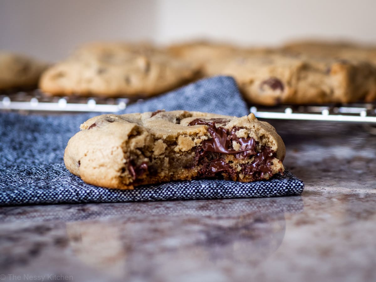 Chocolate chip cookie on a napkin with a bite taken out.