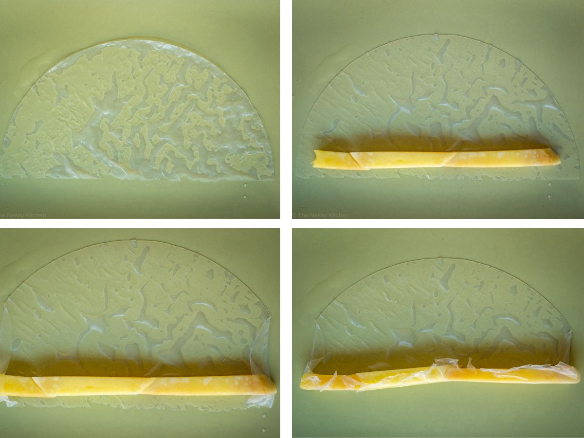 Rice paper being folded around a piece of mango to create a straw shape.