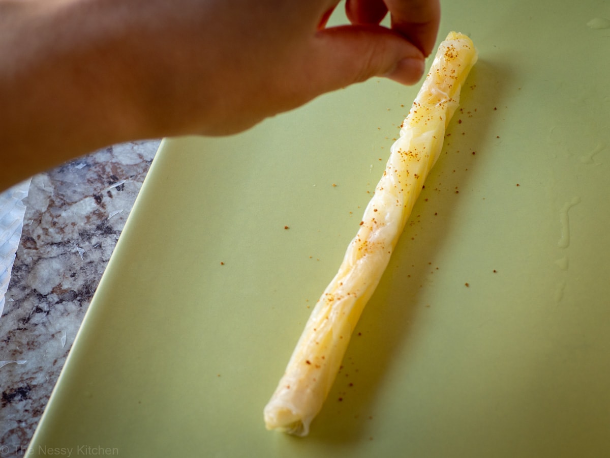 Sugar being sprinkled on the candy straw.