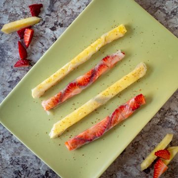 Rice paper candy straws on a green plate.