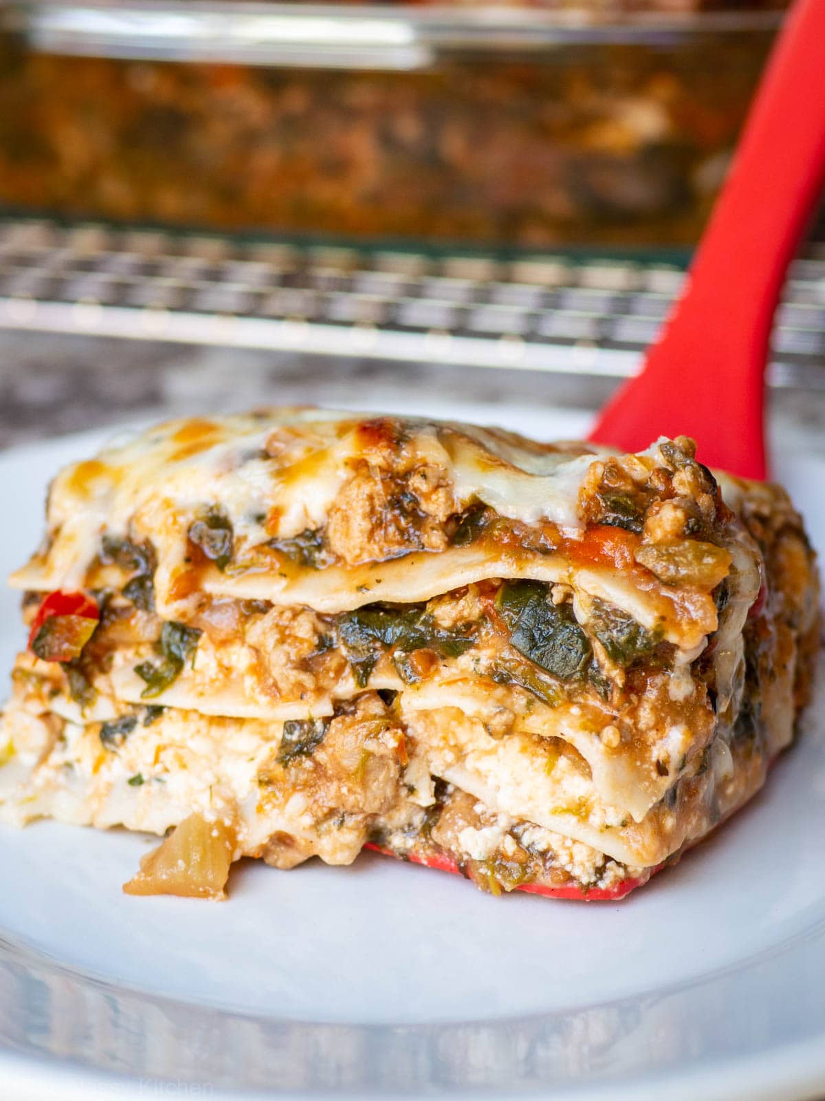 Piece of lasagna lifted onto a plate.