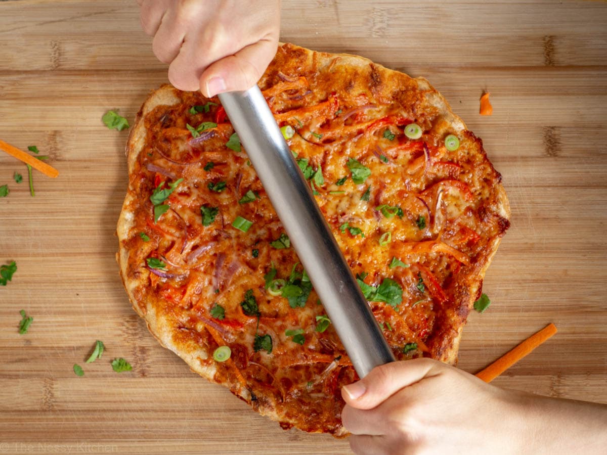 Baked Thai curry pizza being sliced.