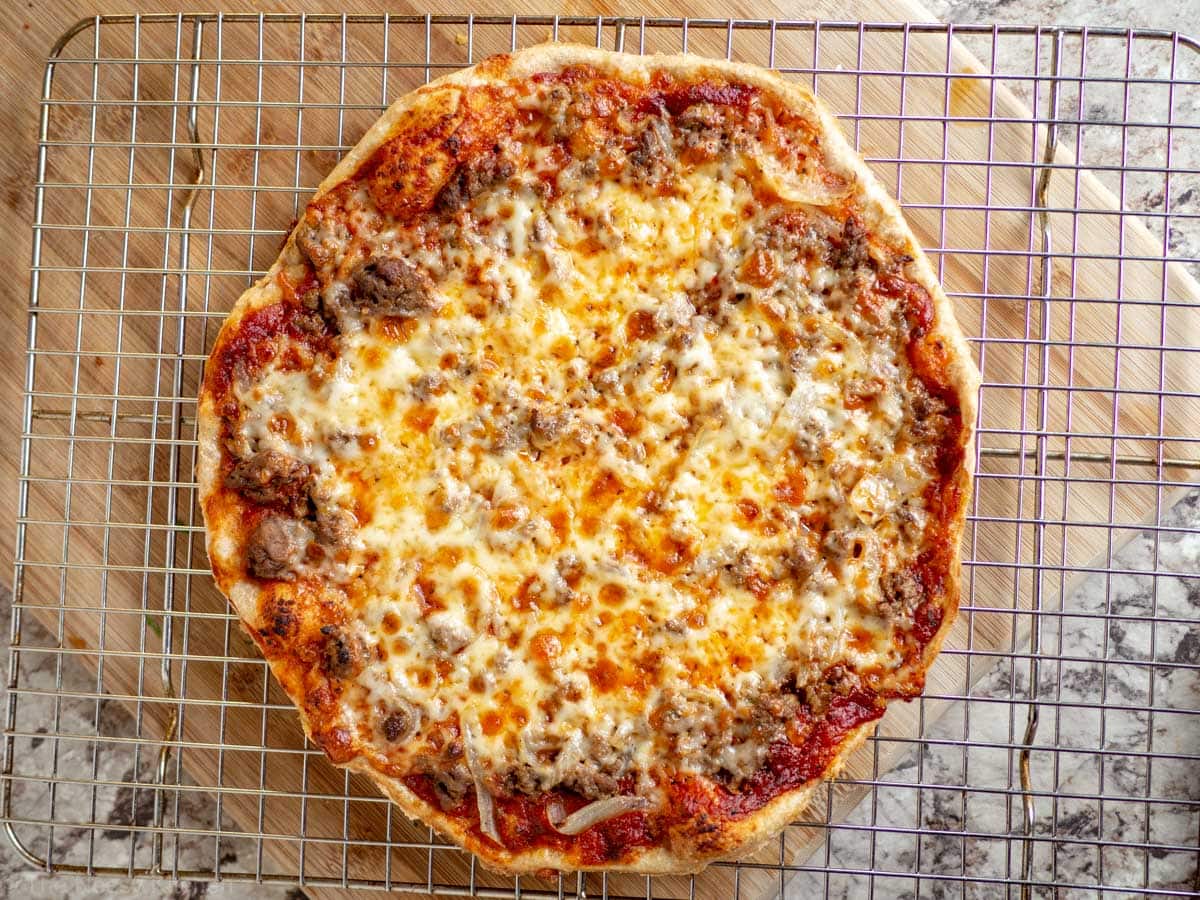 Ground beef pizza on a wire cooling rack.