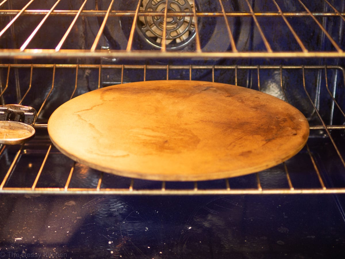 Pizza stone preheated in an oven.