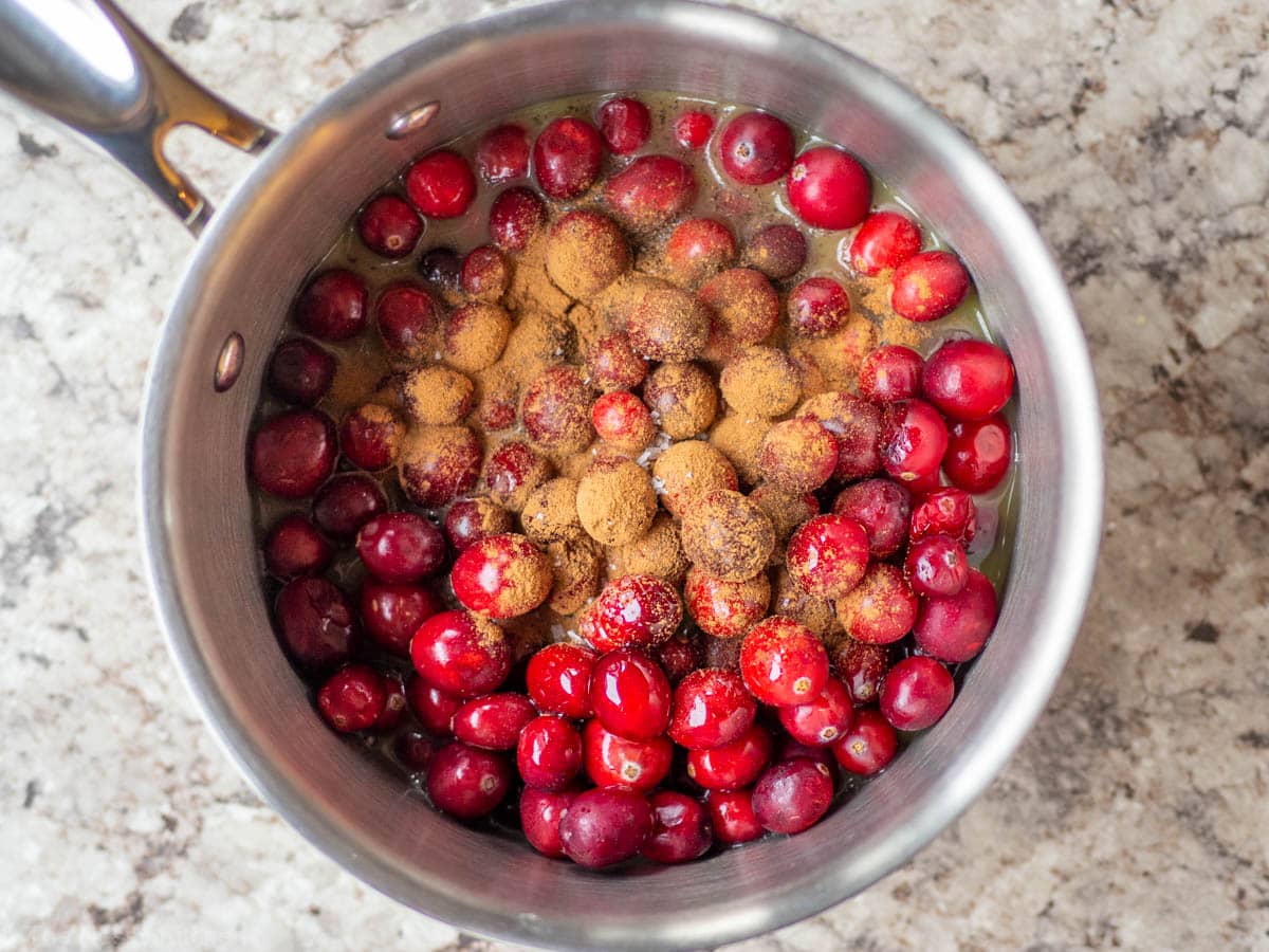 Cranberry sauce ingredients added to a small sauce pan.