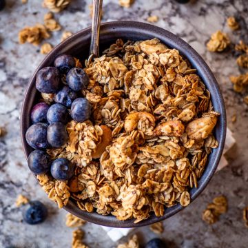 Bowl of granola topped with blueberries.
