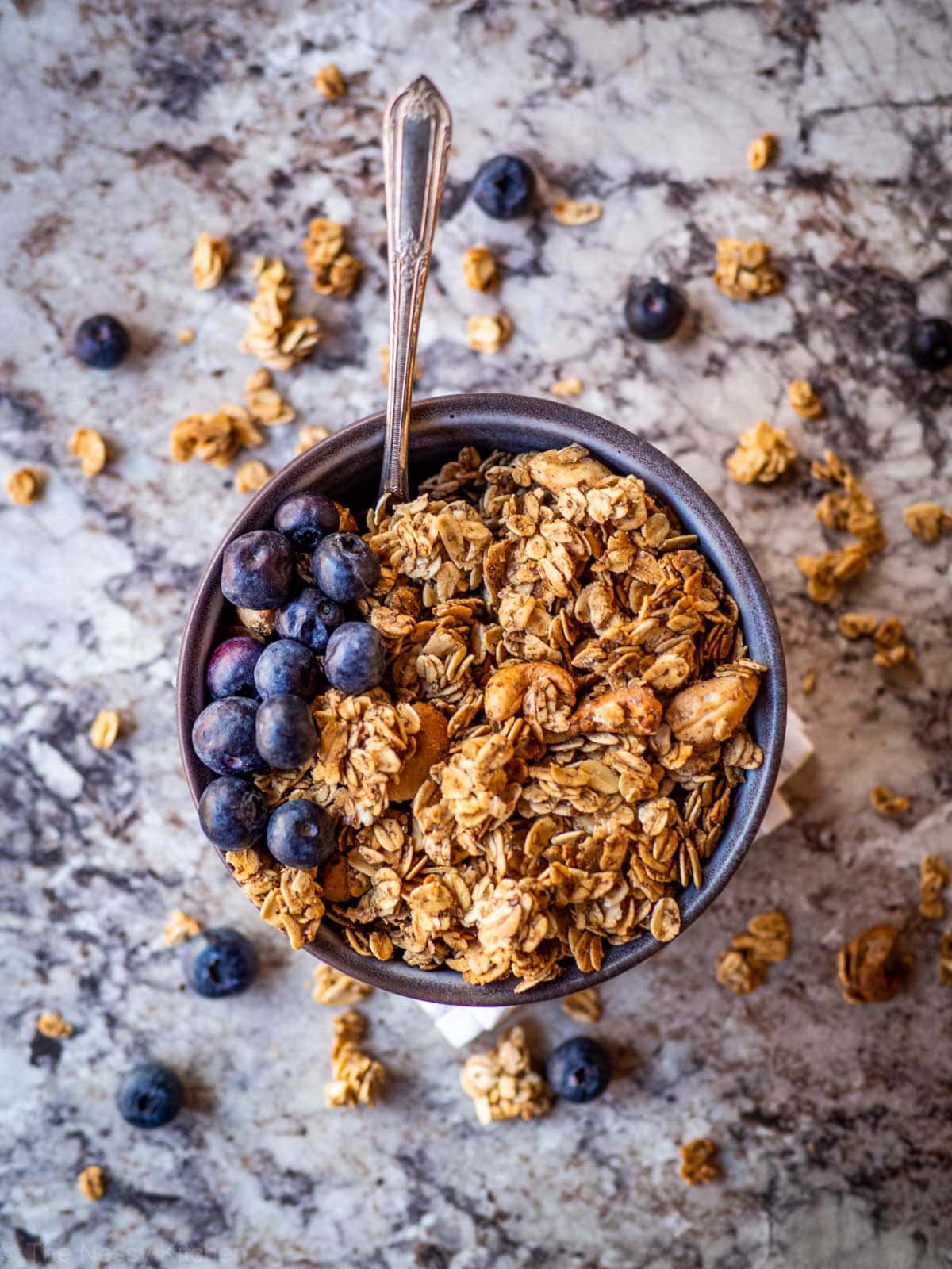 Bowl of granola topped with blueberries.
